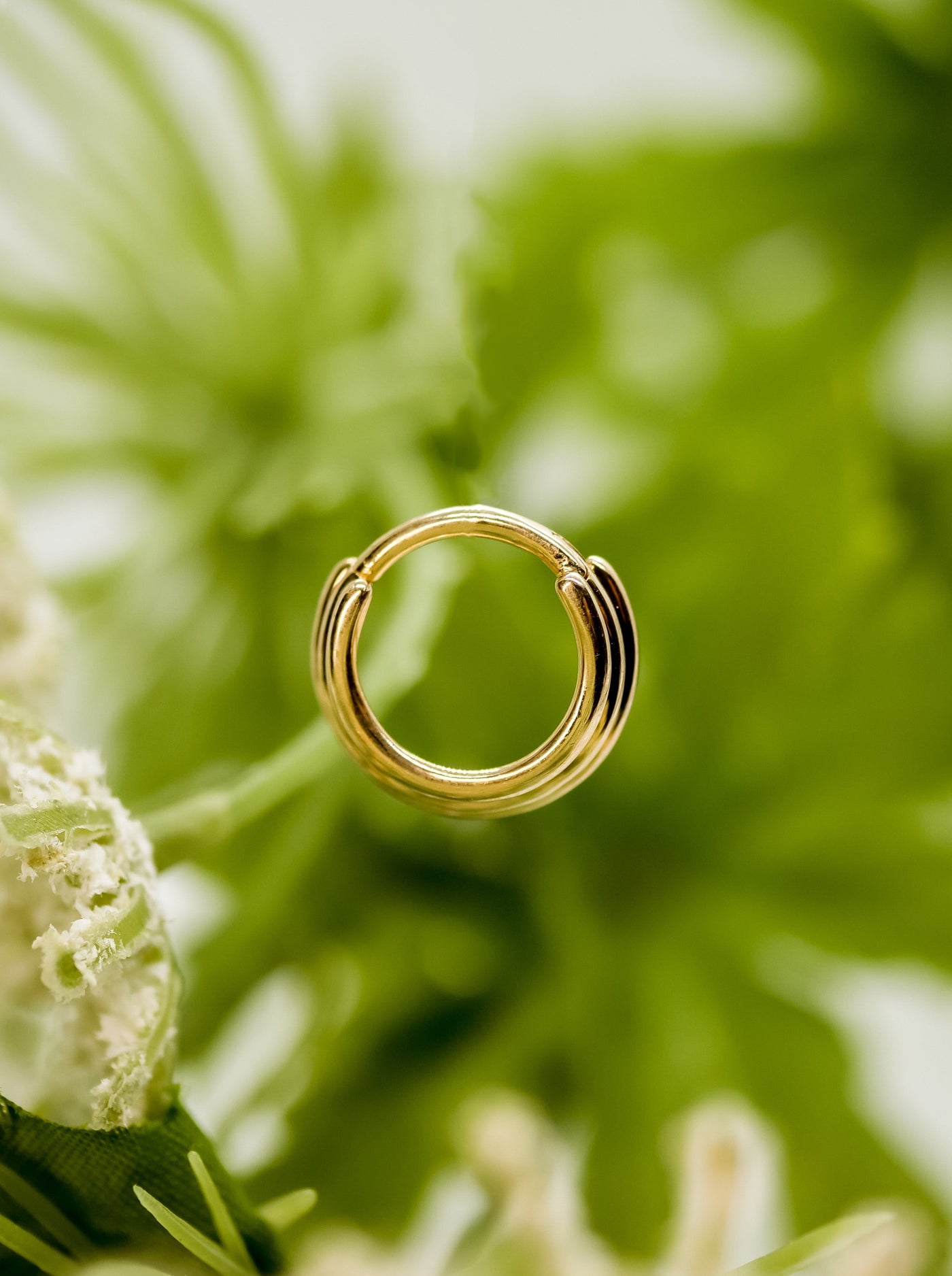 the appearance of a stretched seotum ring with multiple hoops in nose segment ring clicker in yellow gold