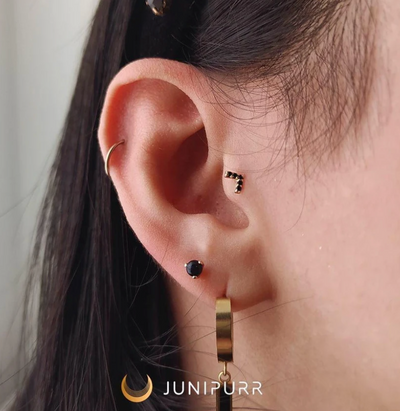 junipurr body jewelry onyx ball shown in upper lobe ear piercing curated project, featuring a clack chevron piece in tragus 