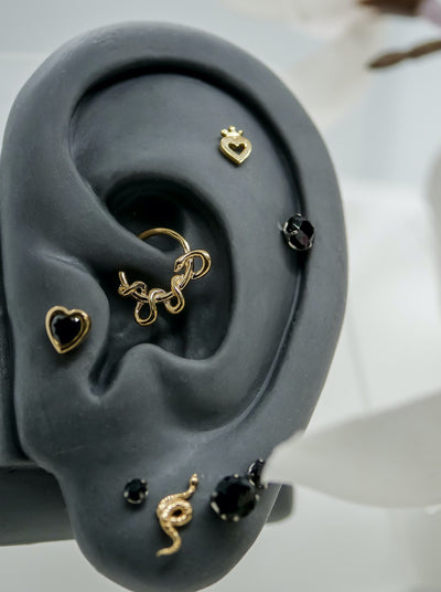 ear piercing curated project featuring threadless ends by junipurr and neometal, kaa hoop snake hoop, with crown heart threadless end, snake end, black prong ends and black heart 
